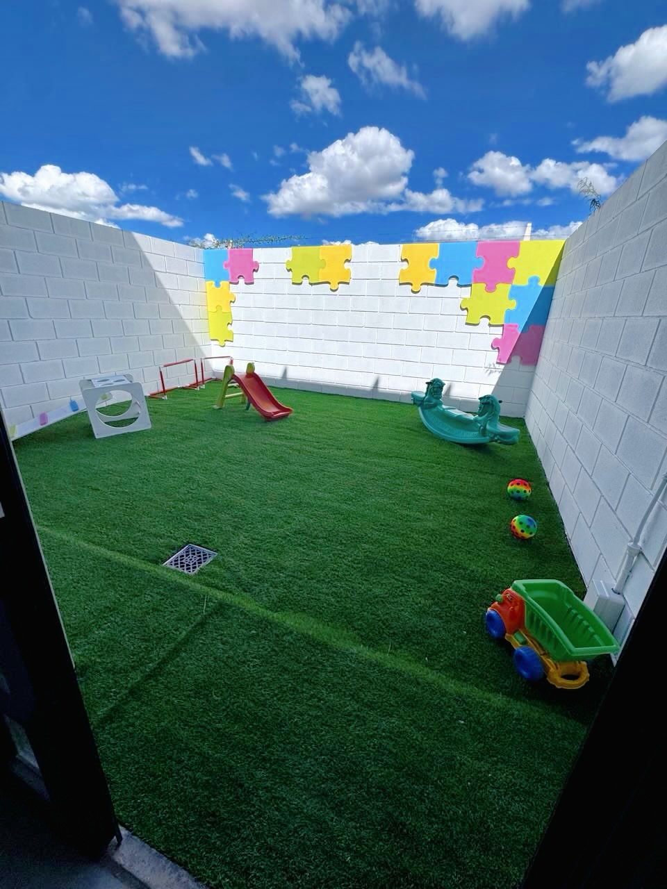 El patio de Jugarte con césped, tobogán y juegos al aire libre